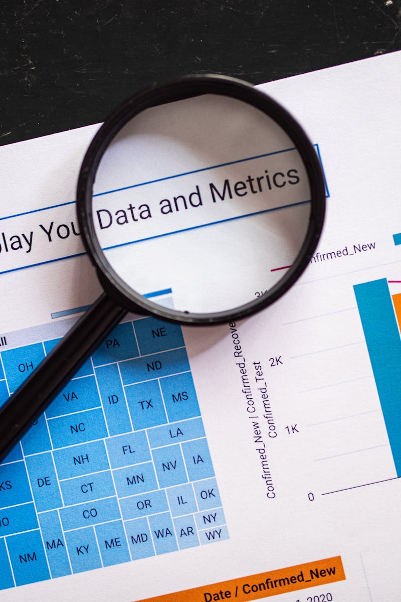 Close-up of business charts with magnifying glass highlighting data insights.